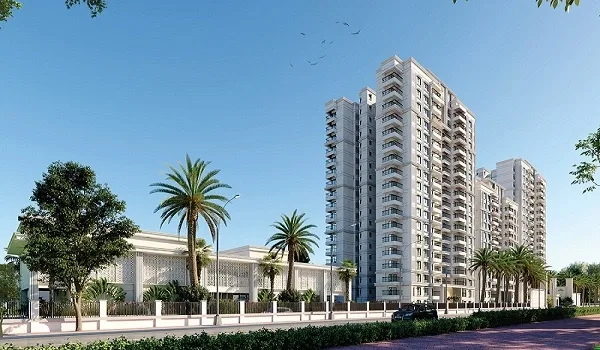 High-rise apartment towers in cream and white behind palm trees and a boundary wall