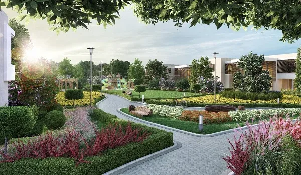 Paved walking path curving through flowering beds, clipped hedges and lawns with low-rise homes beyond