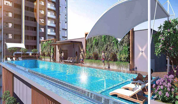 Long outdoor swimming pool with sun loungers, a shaded canopy and a green wall, framed by residential blocks